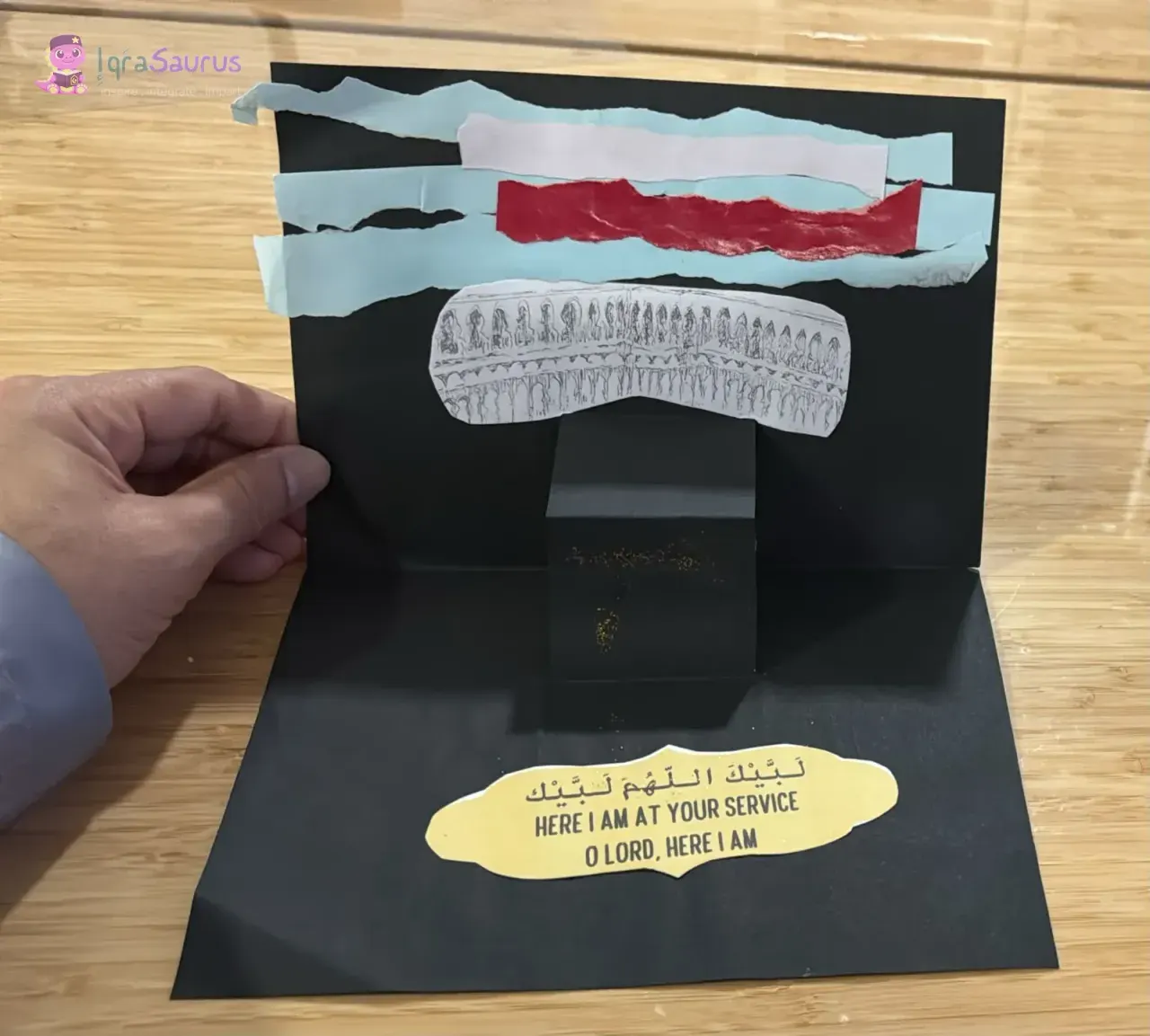 The third panel: a pop-up Ka'bah with a torn-paper sky, and the Talbiyah below it